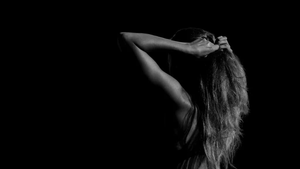 Woman from behind tying her hair up